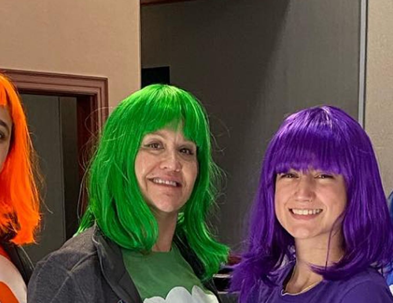 Vibrant Orthodontics team members in colorful wigs, demonstrating a fun and personalized experience.